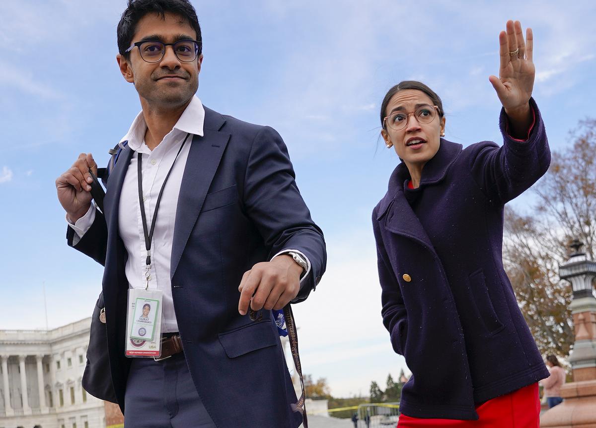  Rep.-elect Alexandria Ocasio-Cortez, D-NY., right, and her chief of staff Saikat Chakrabarti, left, walk back together after joining other members of the freshman class of Congress for a group photo on Capitol Hill in Washington, Wednesday, Nov. 14, 2018. (AP Photo/Pablo Martinez Monsivais) 