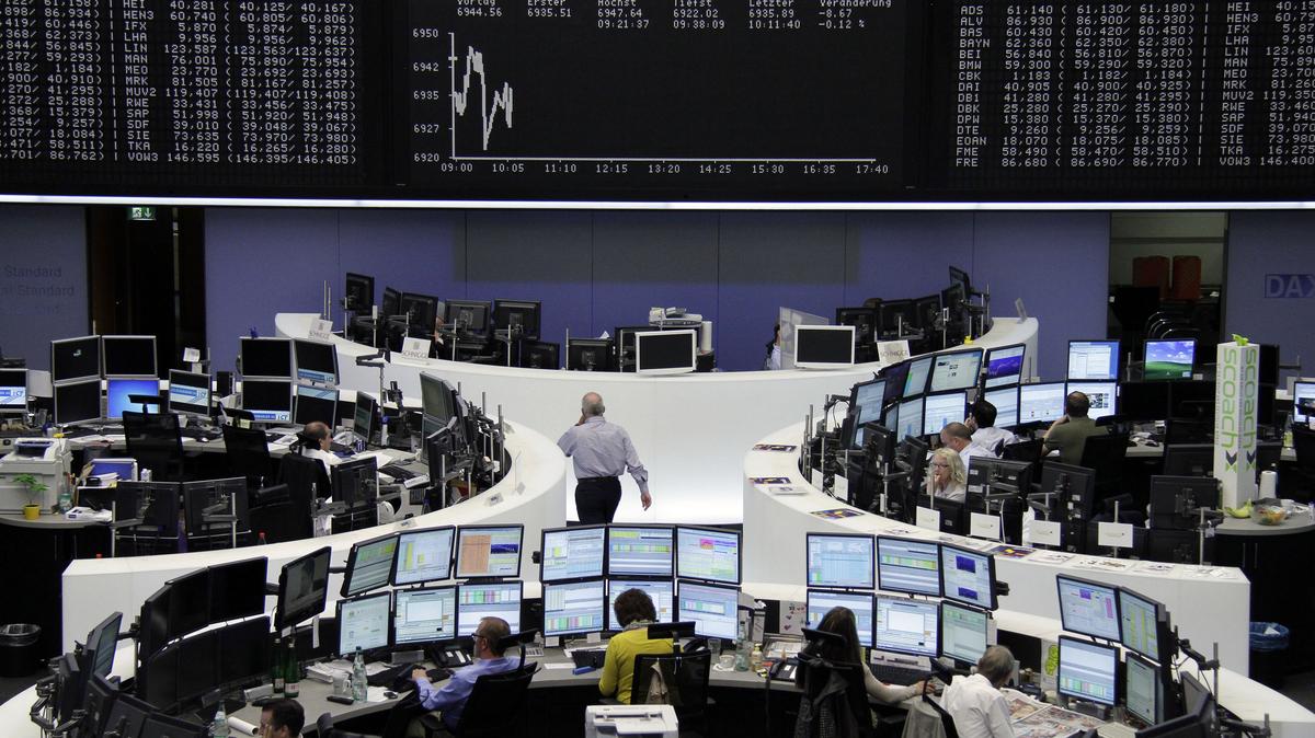 Traders sit at their desks in front of the DAX board at the Frankfurt stock exchange August 13, 2012. REUTERS/Remote/Tobias Schwarz (GERMANY - Tags: BUSINESS)