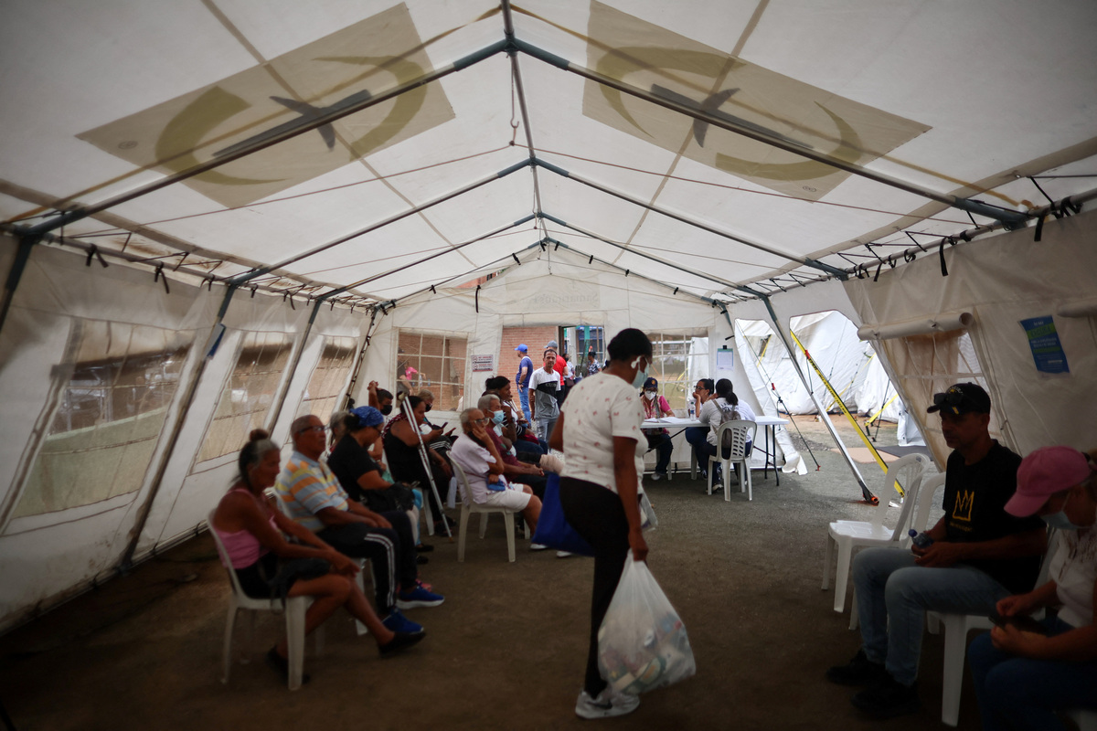 People sit at a field hospital, which is part of the U.S. State Department's coordination, in the aftermath of the June 24 earthquakes, in La Guaira, Venezuela, July 4, 2026. REUTERS/Adriano Machado