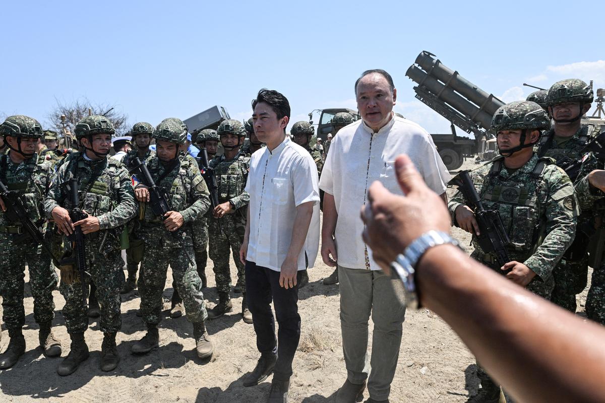 Japan's Defense Minister Shinjiro Koizumi and Philippine Secretary of National Defense Gilberto Teodoro walk during the Joint Task Force (JTF) Maritime Strike, part of Balikatan, the annual joint military exercises between the United States and the Philippines, at Culili Point Sand Dunes, Paoay, Ilocos Norte province, Philippines, May 6, 2026. REUTERS/Noel Celis