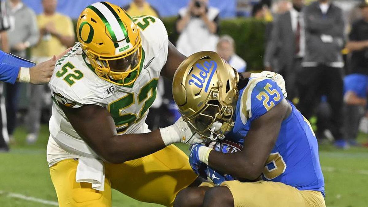  Sep 28, 2024; Pasadena, California, USA; Oregon Ducks defensive lineman A'Mauri Washington (52) tackles UCLA Bruins running back T.J. Harden (25) in the backfield during the third quarter at Rose Bowl. Mandatory Credit: Robert Hanashiro-Imagn Images | Robert Hanashiro-Imagn Images 