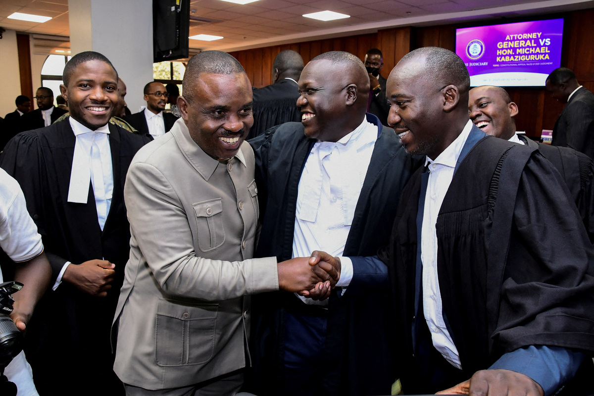 FILE PHOTO: Lawyers Erias Lukwago, Caleb Alaka and Samuel Muyizi celebrate their win in the Supreme Court of Uganda after the court ruled that civilians should no longer be charged in the military courts at the Judiciary head quarters in Kampala, Uganda January 31, 2025. REUTERS/Abubaker Lubowa/File Photo
