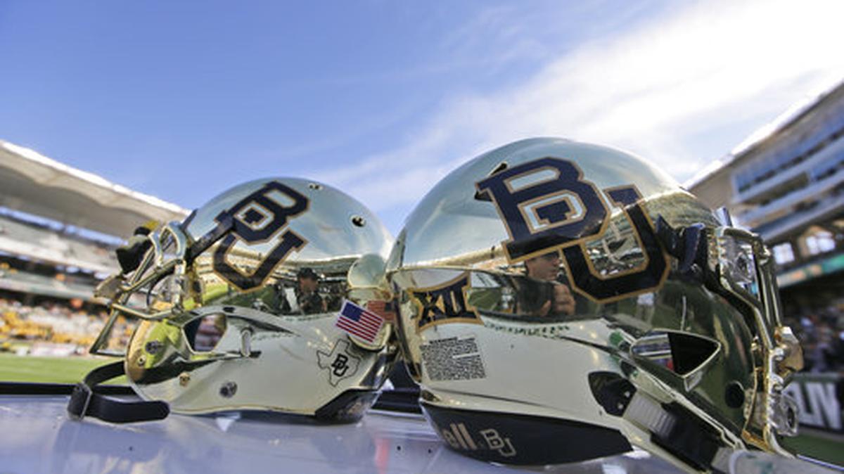FILE - In this Dec. 5, 2015, file photo, Baylor helmets on shown the field after an NCAA college football game in Waco, Texas. The NCAA is conducting an “ongoing, pending investigation” into Baylor University in the wake of a sexual assault scandal that led to the firing of football coach Art Briles and the departure of the school president, the school’s lawyers confirmed in a federal court filing.