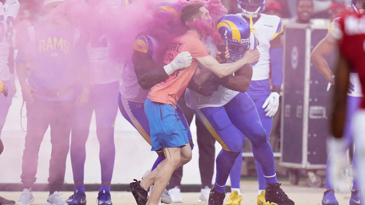 A protester is hit by Los Angeles Rams defensive end Takkarist McKinley, middle left, and linebacker Bobby Wagner during the first half of an NFL football game between the San Francisco 49ers and the Rams in Santa Clara, Calif., Monday, Oct. 3, 2022. (AP Photo/Godofredo A. Vásquez)