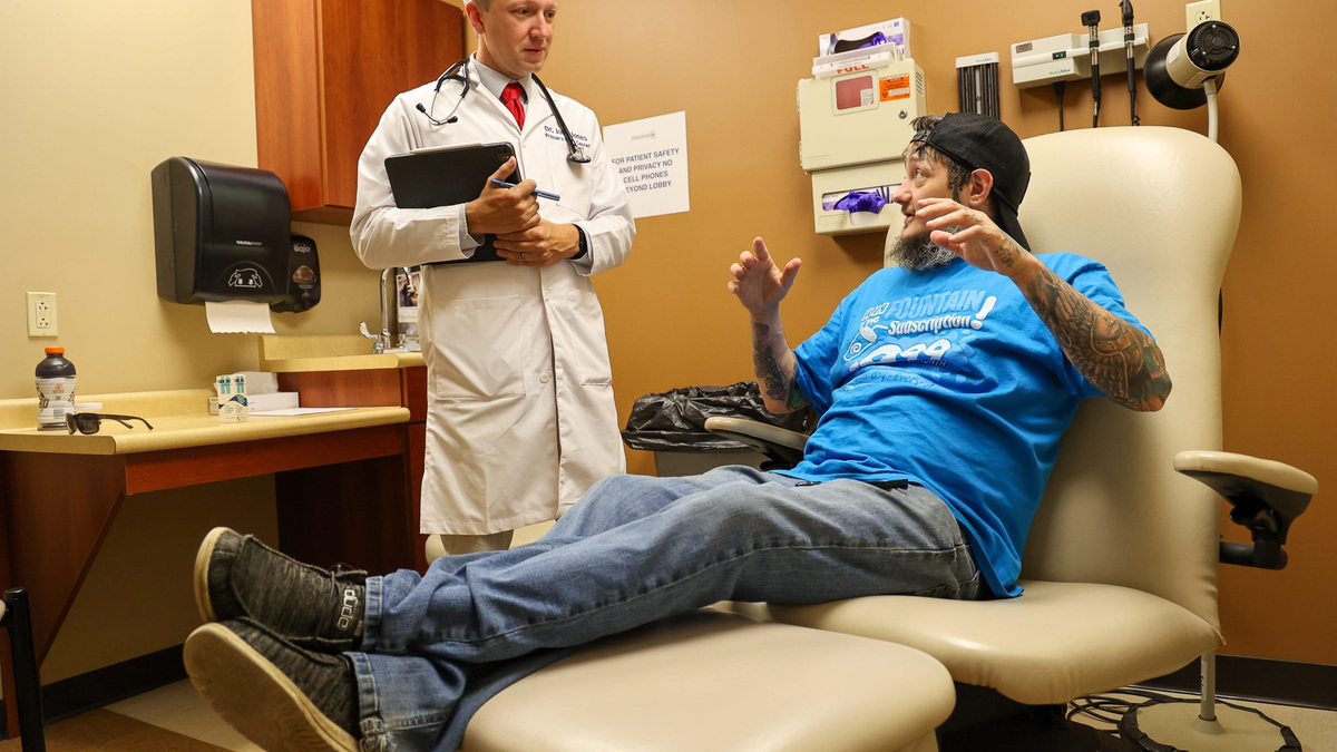 Patient Denver Feltner talks with a physician at the Primary Care Centers of Eastern Kentucky clinic in Perry County, Kentucky.