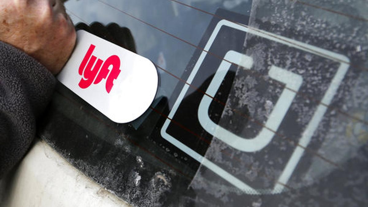 En esta foto de archivo del 31 de enero de 2018, se instaló un logotipo de Lyft en el automóvil de un conductor de Lyft junto a una pegatina de Uber en Pittsburgh.