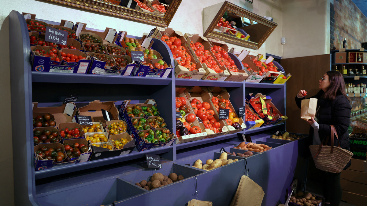 A customer shops for vegetables at gourmet grocery store Andreas, in London, Britain, March 28, 2024. REUTERS/Isabel Infantes
