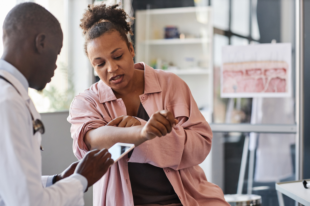  A stock image of a woman suffering from psoriasis visiting a dermatologist. 