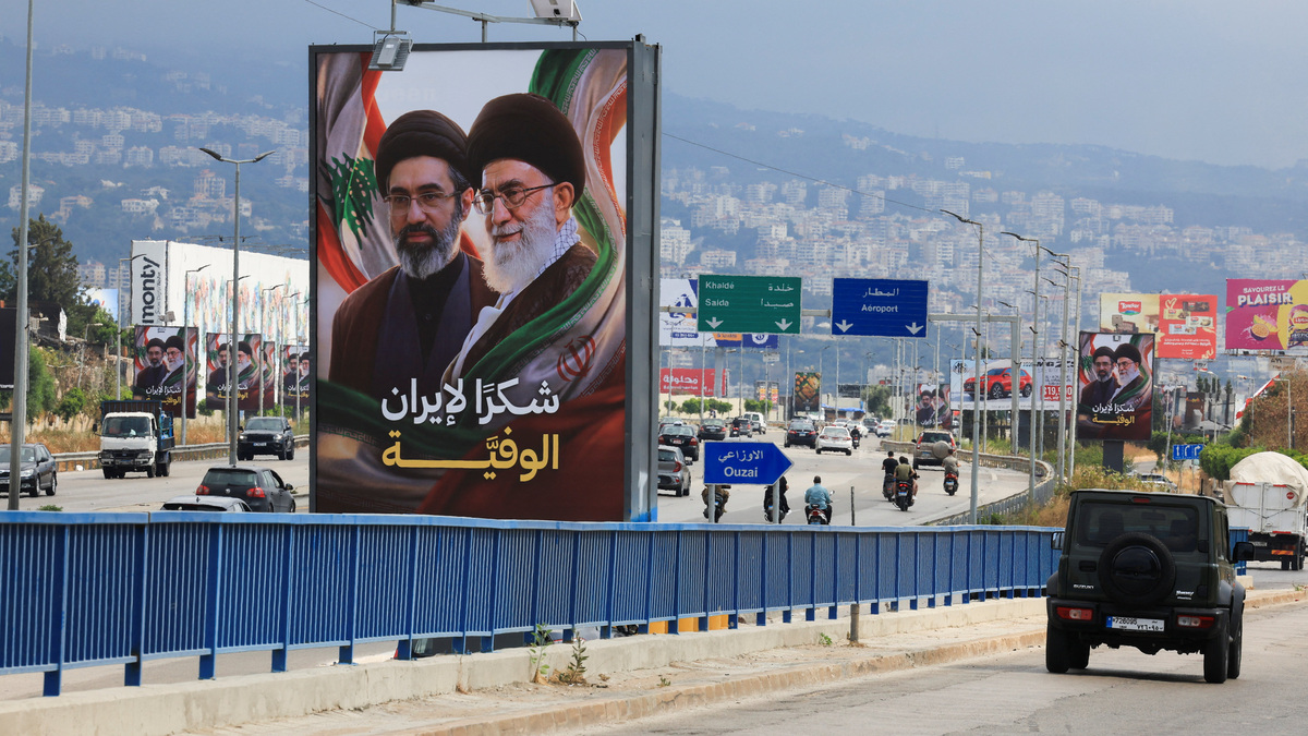 Cars and motorbikes drive past billboards showing Iran’s new Supreme Leader Ayatollah Mojtaba Khamenei and his late father Ali Khamenei, with the slogan “Thank you to loyal Iran,” erected along the highway leading to Rafic Hariri International Airport in Beirut, Lebanon June 22, 2026.REUTERS/Mohamed Azakir