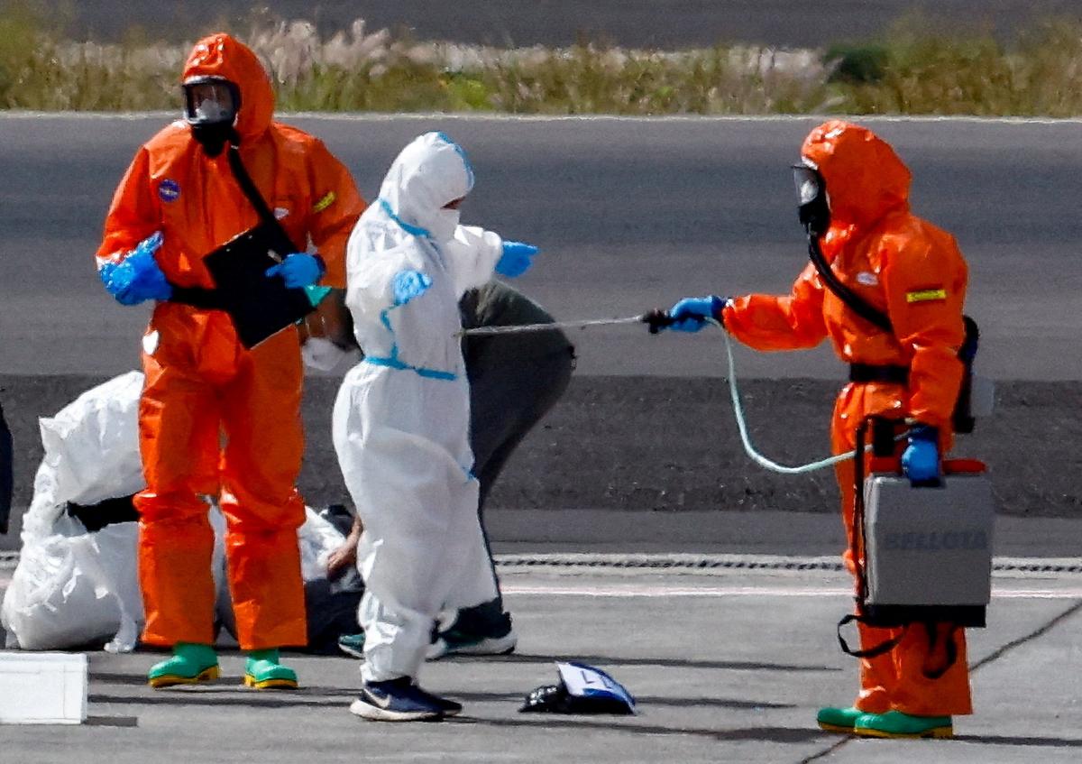 FILE PHOTO: A passenger of the cruise ship MV Hondius, which was affected by a hantavirus outbreak, gets disinfected on the tarmac at Tenerife Sud airport,  Canary Islands, Spain, May 10, 2026. REUTERS/Borja Suarez/File Photo