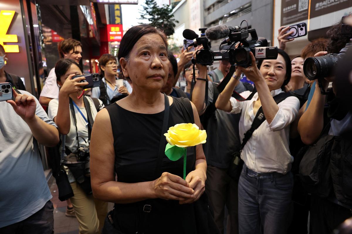 Activist Chan Po Ying holds an artificial flower walking near Victoria Park, the site of past candlelight vigils marking the Tiananmen Square crackdown in 1989, in Hong Kong, China, June 4, 2026. REUTERS/Tyrone Siu