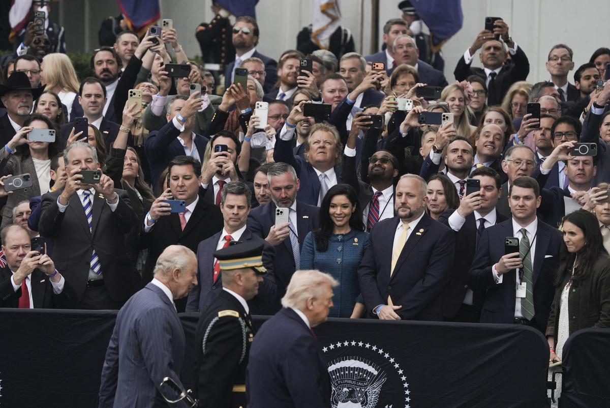 Attendees take photos and videos with their phones as President Donald Trump and King Charles III walk past during an arrival ceremony on the South Lawn of the White House in Washington, on Tuesday, April 28, 2026. (Salwan Georges/The New York Times)