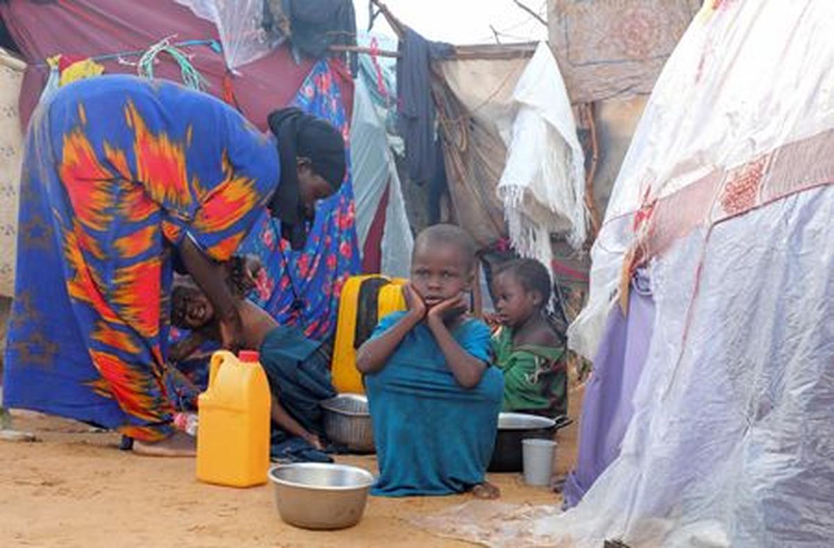 An internally displaced family prepare breakfast outside their makeshift shelter during a visit by World Food Programme’s Assistant Executive Director for Programme Operations, Matthew Hollingworth (not in the photo), to assess the knock on effects from the escalation in the Middle East, alongside drought and sharp cuts in humanitarian funding that are worsening hunger, in Kahda district of Mogadishu, Somalia May 7, 2026. REUTERS/Feisal Omar