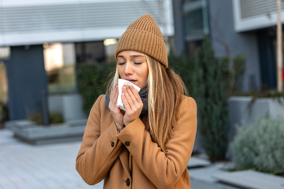 A stock image of a woman blowing her nose. 