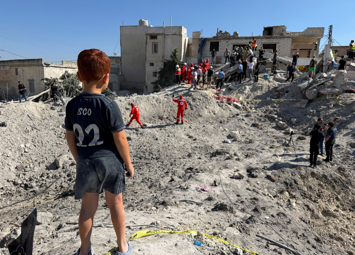 A child stands next to the rubble of a building damaged in an Israeli strike in Qennarit, southern Lebanon, June 20, 2026. Picture taken with a mobile phone. REUTERS/Stringer