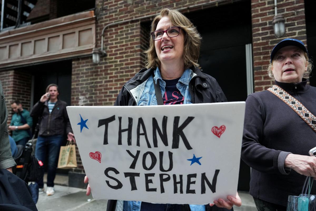 A person holds a ‘Thank you Stephen’ sign outside of the Ed Sullivan Theater before the taping of the final episode of the "The Late Show" with Stephen Colbert, in New York City, U.S., May 21, 2026. REUTERS/Adam Gray