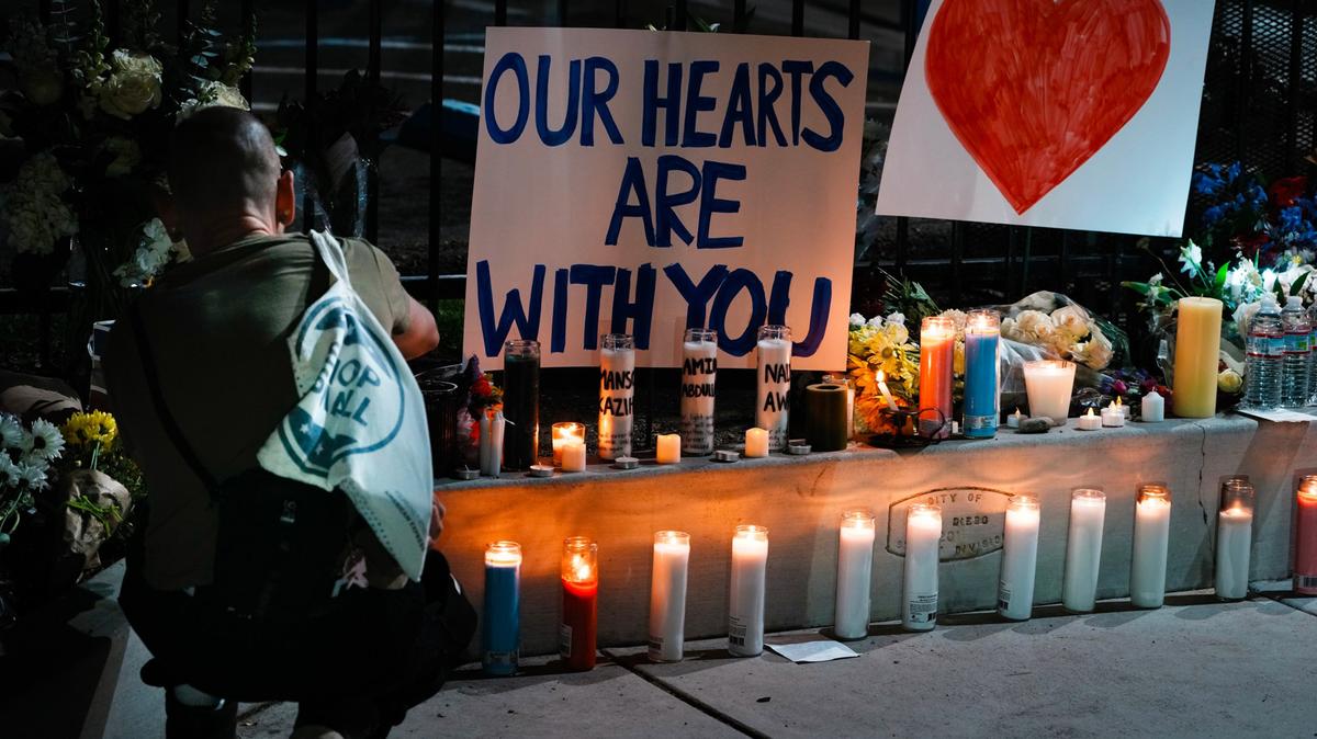 Two unidentified women grieve for a security officer who was killed at the Islamic Center of San Diego on May 19. Two teen gunmen shot and killed three people at the center, authorities said, before the suspects killed themselves.