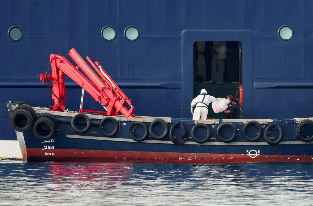 A person wearing personal protective equipment (PPE) on a boat transfers a package to the cruise ship MV Hondius at the port of Granadilla de Abona after being affected by a hantavirus outbreak in Tenerife, Spain, May 10, 2026. REUTERS/Hannah McKay