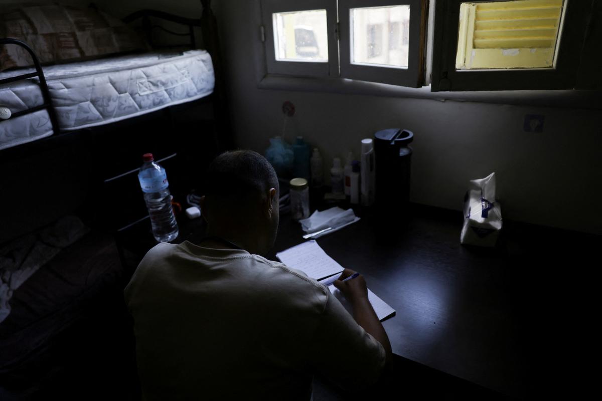 An Egyptian transgender man who escaped from Egypt due to persecution and asked to be identified by the name Mina for security reasons, writes about his hopes in a temporary shelter for displaced people, in Beirut, Lebanon, May 4, 2026. REUTERS/Raghed Waked.