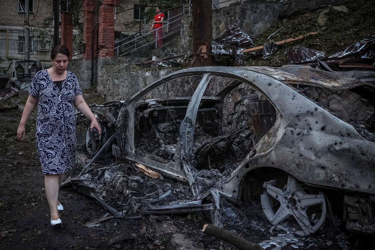 A resident walks past burnt cars following overnight Russian missile and drone strikes, amid Russia’s attack on Ukraine, in Kyiv, Ukraine, July 2, 2026. REUTERS/Alina Smutko