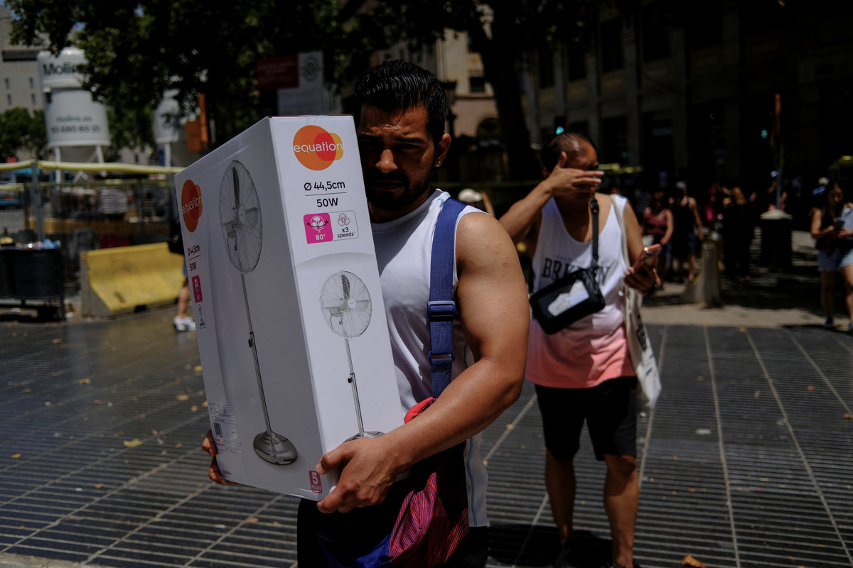 A man carries a newly purchased fan as temperatures rise, during a heatwave affecting a large part of Spain, in Barcelona, in Spain, June 21, 2026. REUTERS/Nacho Doce