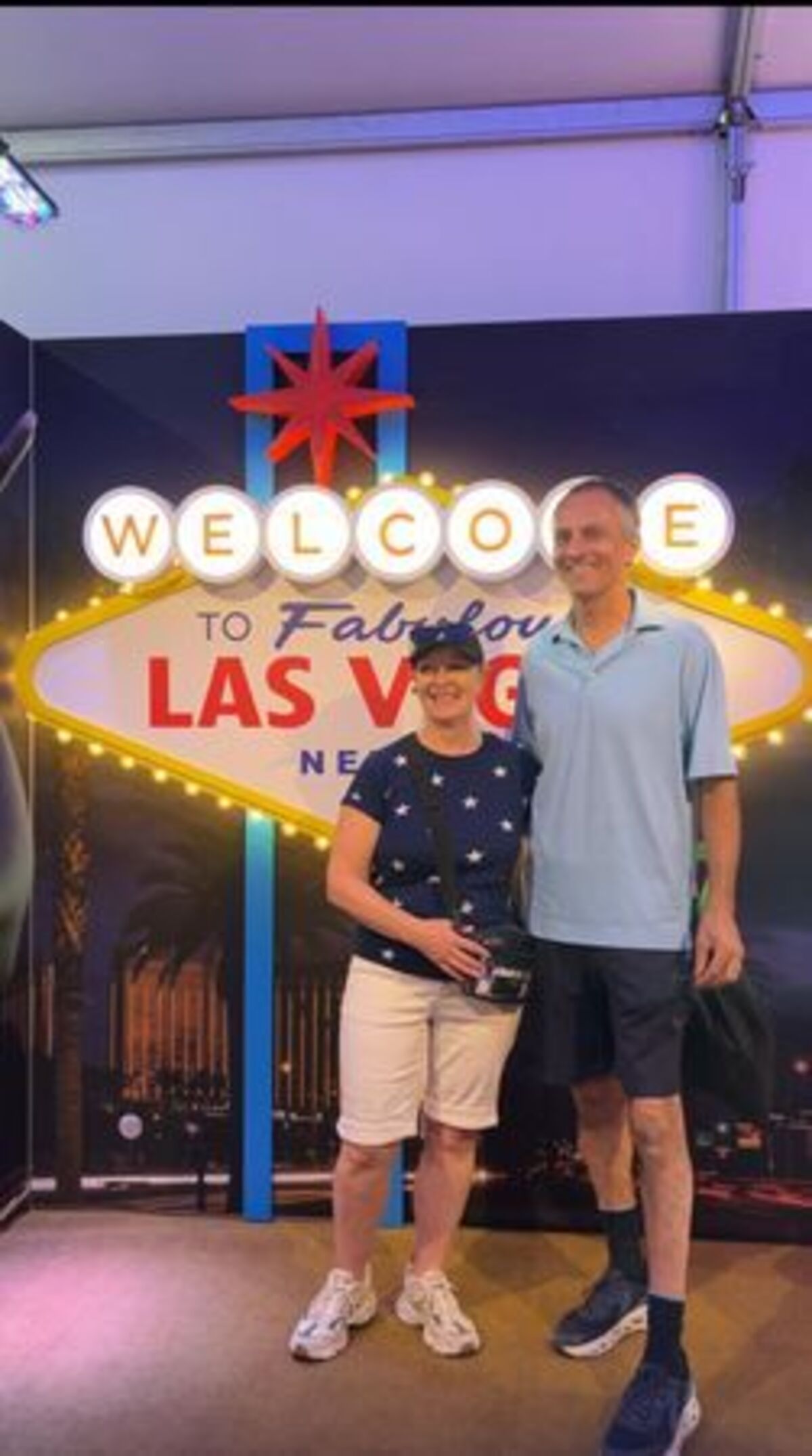 Michelle and Paul Catan, in their 60s, from Oneonta, New York, take a photo with the Las Vegas sign in the Nevada tent.