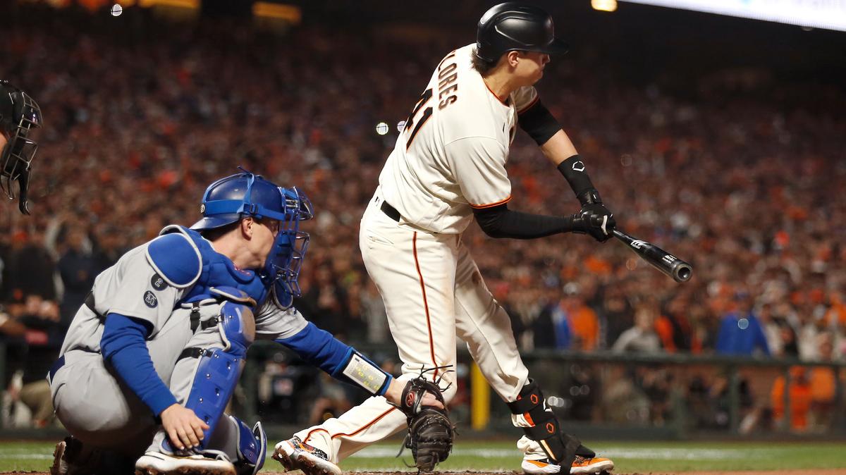 San Francisco Giants’ Wilmer Flores, right, is called out swinging in front of Los Angeles Dodgers catcher Will Smith for the final out of the ninth inning of Game 5 of a baseball National League Division Series Thursday, Oct. 14, 2021, in San Francisco. (AP Photo/Jed Jacobsohn)