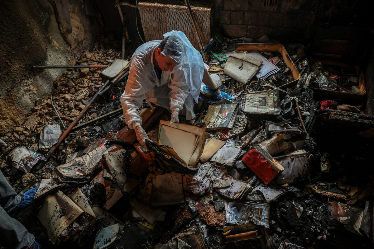 Iryna Plekhova, 42, resident who survived yesterday's Russian missile and drone attack, examines her remaining personal belongings in the burned down apartment, which was damaged during the strike, amid Russia's attack on Ukraine, in Kyiv, Ukraine July 3, 2026. REUTERS/Alina Smutko