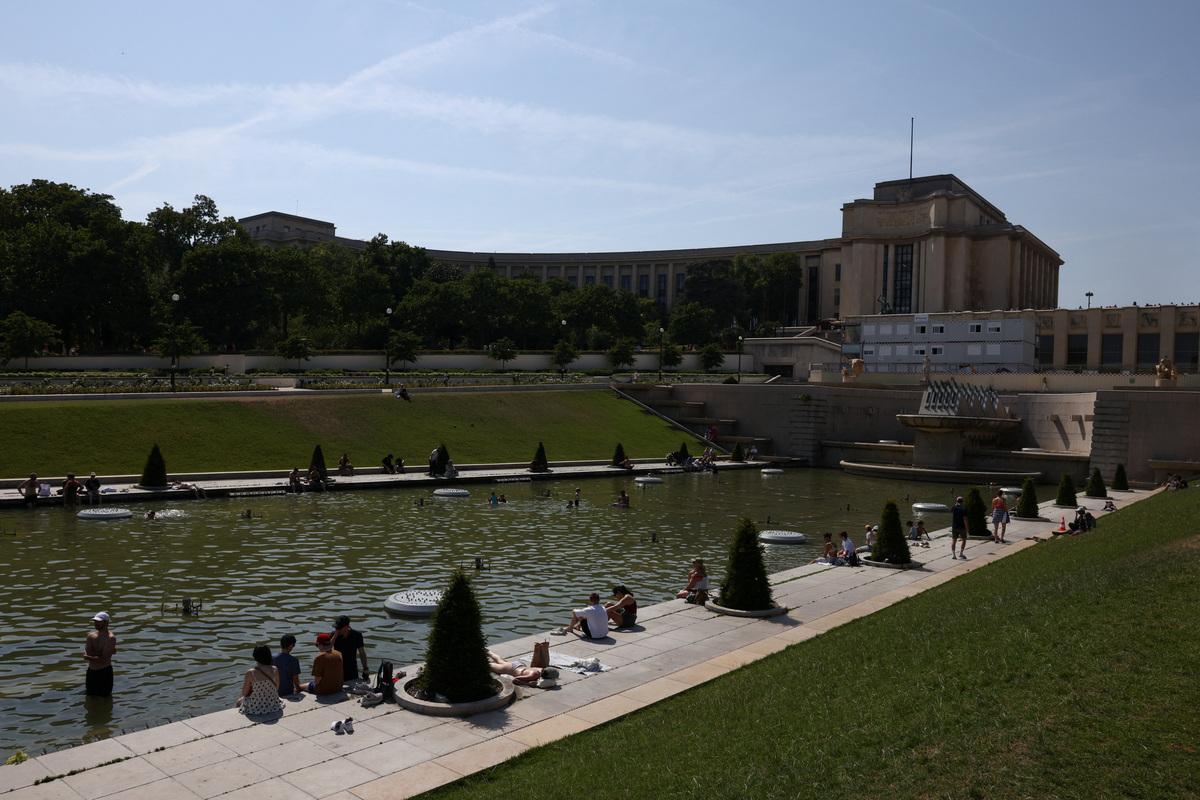 People gather around the Trocadero Fountains by the Eiffel Tower during high temperatures amid a heatwave in Paris, France, June 27, 2026. REUTERS/Tom Nicholson