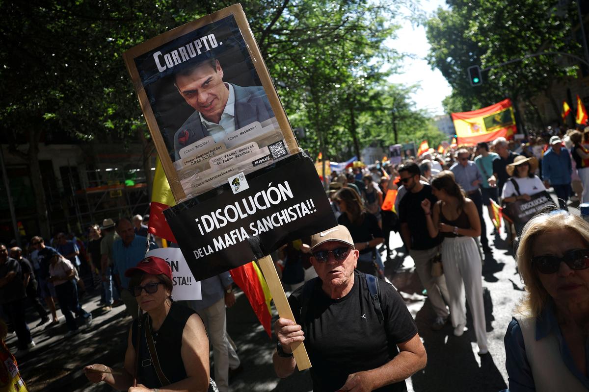 A man holds a poster with a picture of Prime Minister Pedro Sanchez as he takes part in a rally organised by Spain’s far-right VOX party against Prime Minister Pedro Sanchez’s government, in Madrid, Spain, May 23, 2026. REUTERS/Kacper Pempel