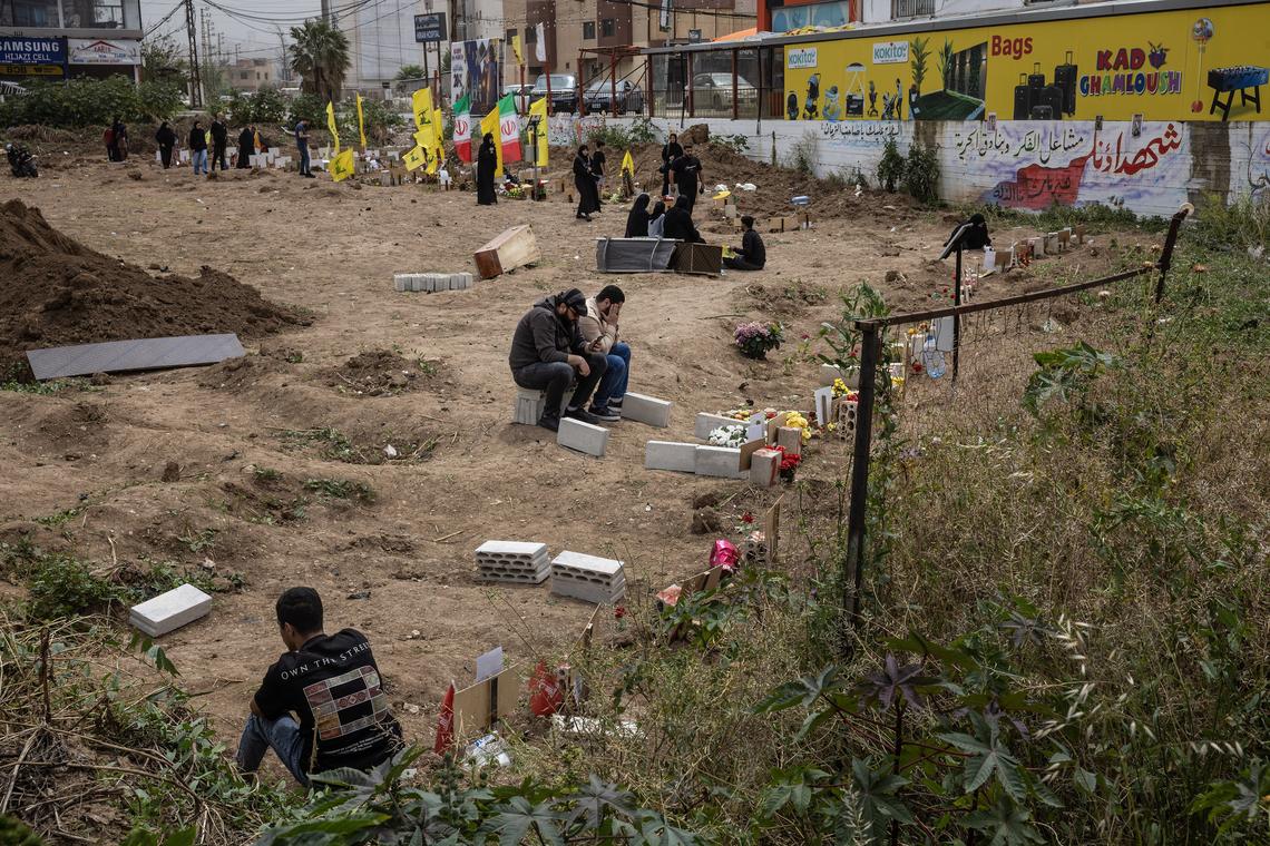 Family members grieve at a cemetery in Tyre, Lebanon, April 18, 2026. Gathering at the cemetery for the first time since the ceasefire, they hope to relocate the remains to their now accessible home villages. (David Guttenfelder/The New York Times)