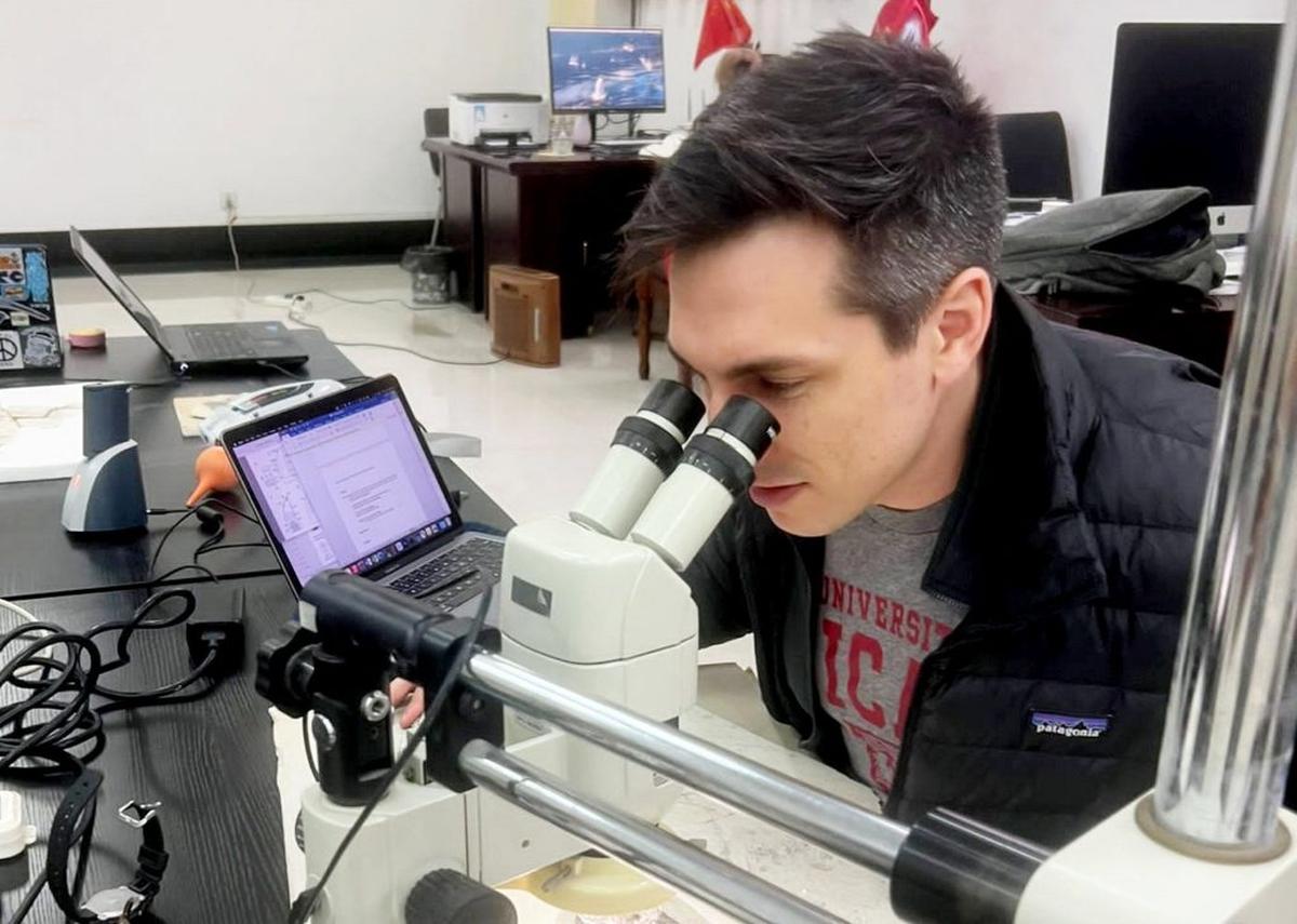 Alex Clark examining the Plumadraco fossil. (Courtesy of Alex Clark via SWNS) 