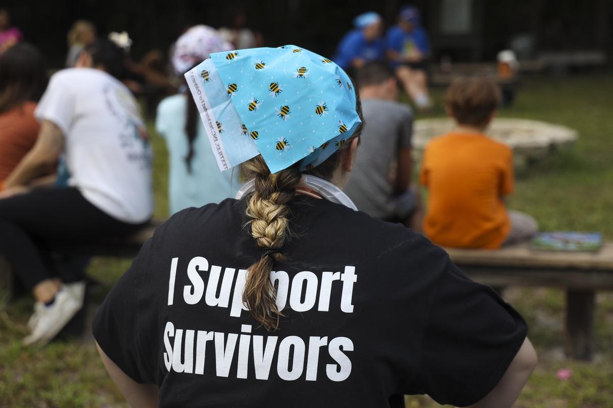 A counselor wears a “I support survivors,” T-shirt at a camp for Tampa Bay children who have experienced domestic violence.