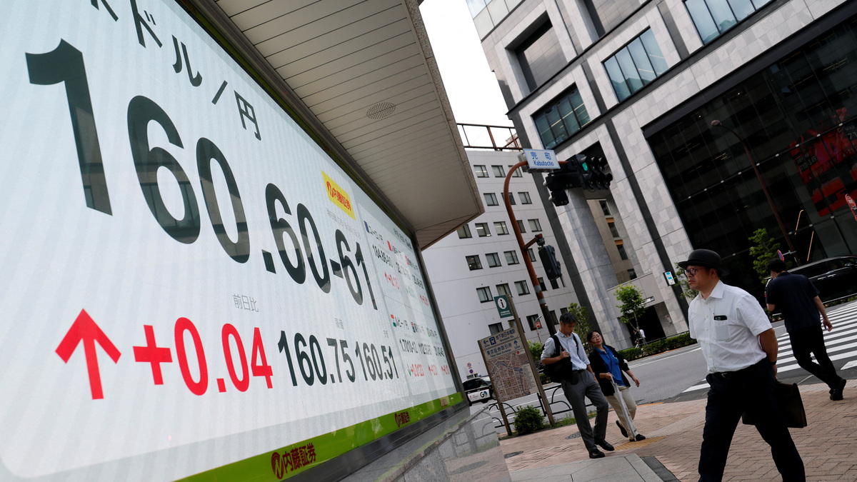 A pedestrian looks at a board showing  the current Japanese yen exchange rates against the U.S. dollar outside a brokerage in Tokyo, Japan, June 18, 2026.    REUTERS/Kim Kyung-Hoon