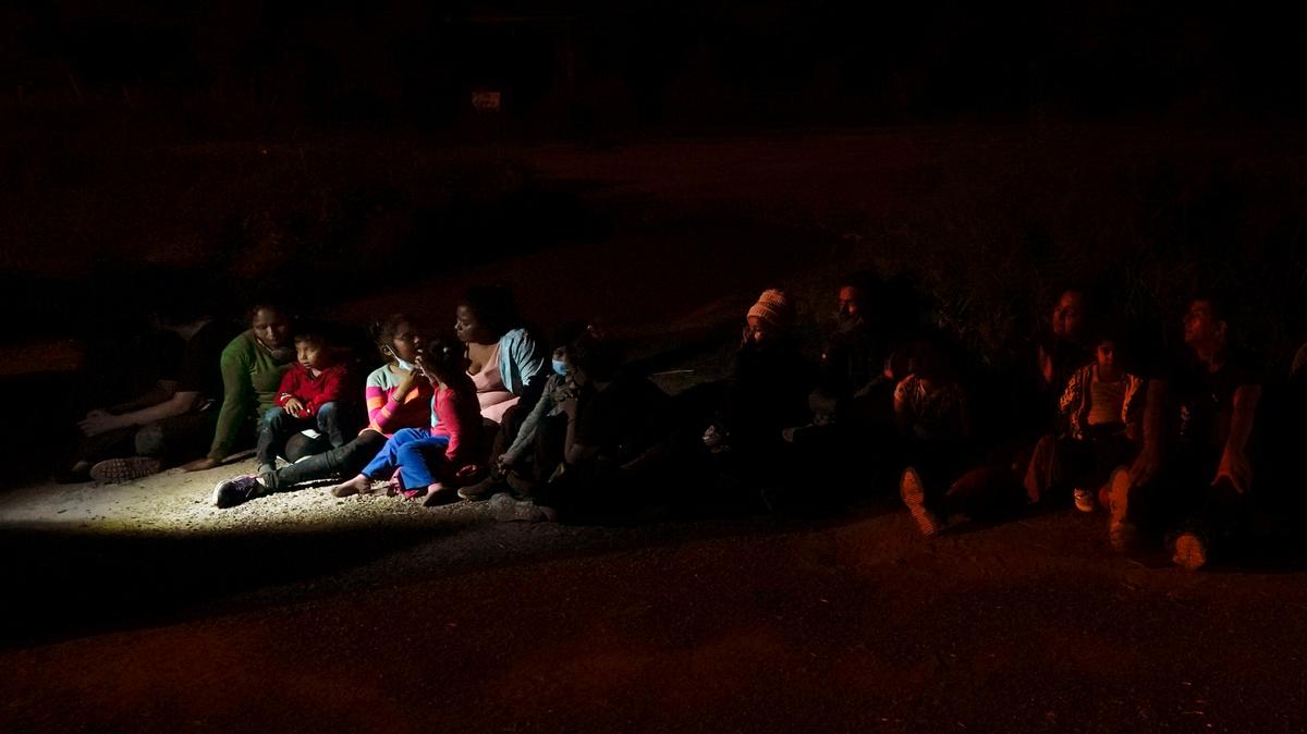 Varios migrantes, principalmente de Honduras y Nicaragua, hacen fila sentados después de entregarse al cruzar la frontera entre Estados Unidos y México, en esta fotografía de archivo del lunes 17 de mayo de 2021 en La Joya, Texas. (AP Foto/Gregory Bull, Archivo)