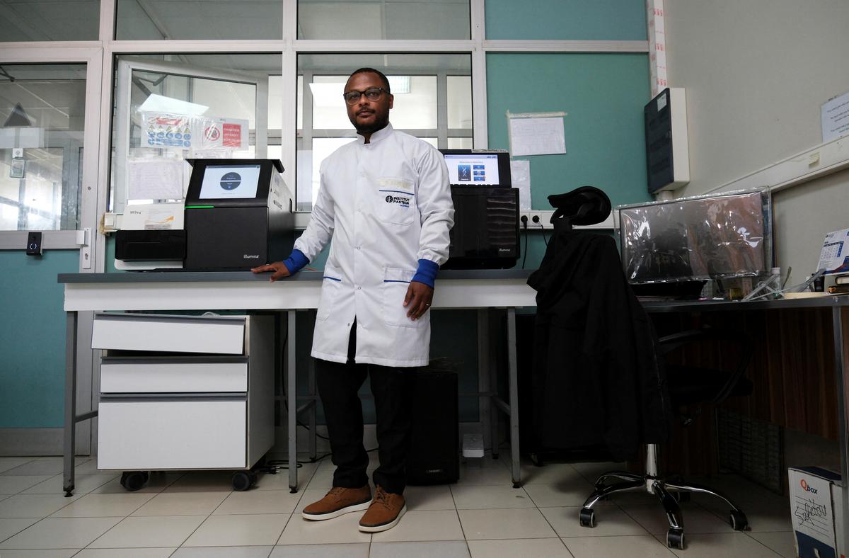 Dr. Moussa Moise Diagne, a virologist and head of the sequencing platform at Institut Pasteur, poses with one of the machines used to sequence the hantavirus genome during the coordinated response to the April 2026 outbreak, at Institut Pasteur in Dakar, Senegal, May 19, 2026. REUTERS/Ricci Shryock