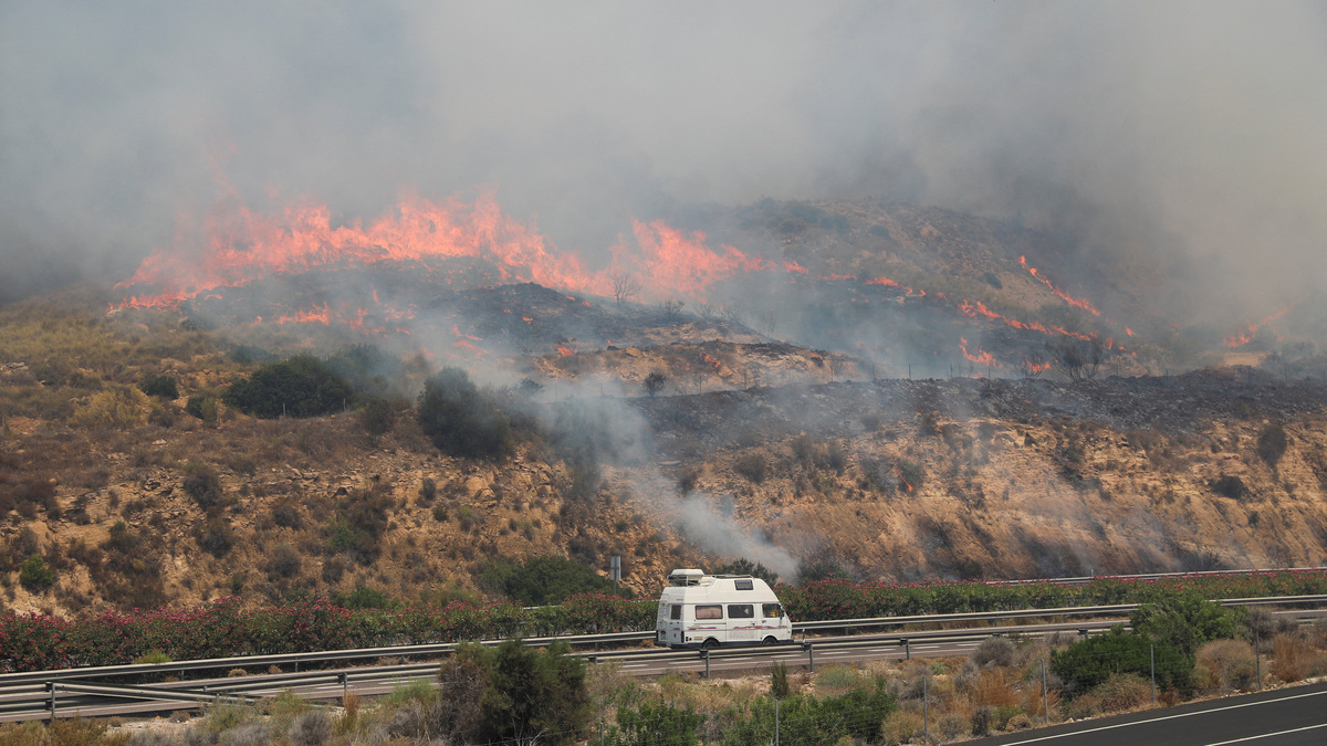 A van drives along the A7 highway as a wildfire approaches in the vicinity of Los Gallardos, in Almeria, Spain, July 10, 2026. REUTERS/Loyola Perez de Villegas Muniz