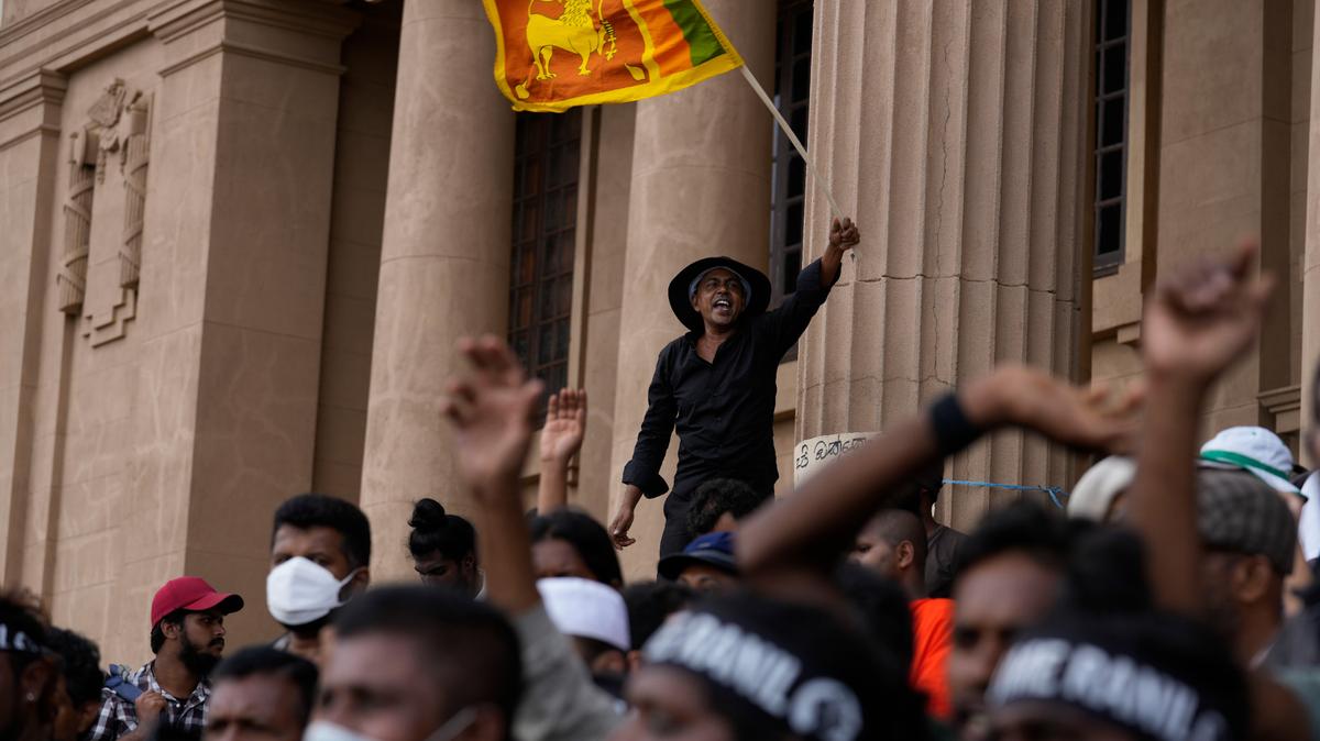 Un manifestante ondea una bandera nacional y grita consignas exigiendo la renuncia del presidente electo Ranil Wickremesinghe durante una protesta en la sede de la secretaría presidencial en Colombo, Sri Lanka, el miércoles 20 de julio de 2022. El primer ministro de Sri Lanka fue elegido presidente el miércoles por legisladores que optaron por un líder experimentado y veterano para sacar al país del colapso económico, a pesar de la oposición pública generalizada. (AP foto/Rafiq Maqbool)