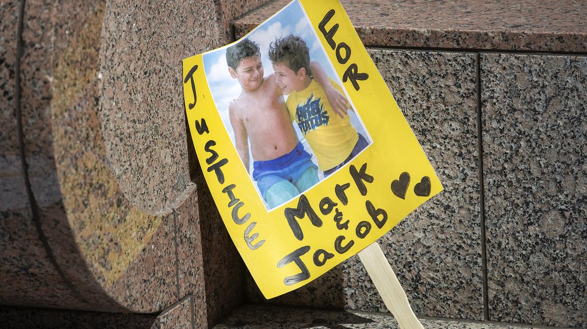 A sign shows an image of Mark Iskander, 11, left, and his brother Jacob Iskander, 8, outside Van Nuys Courthouse where a preliminary hearing was held for Rebecca Grossman, who was charged with murder and other counts stemming from a crash that killled the boys in a crosswalk. (Mel Melcon/Los Angeles Times/TNS)
