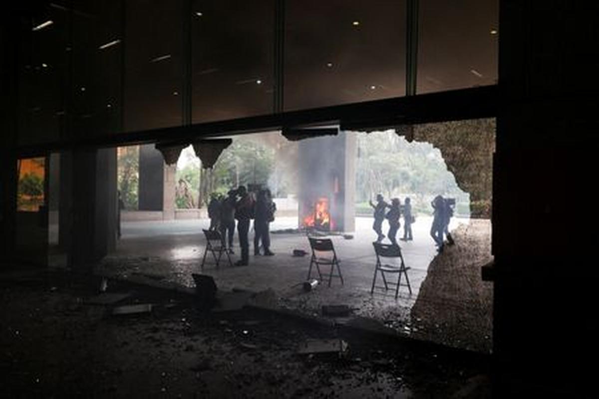 Members of the media work outside the Secretariat of Public Education (SEP) after it was vandalized by dissident teachers from Mexico's National Coordination of Education Workers (CNTE) during a protest to demand better wages and pensions, under the slogan "If there's no solution, the ball won't roll," ahead of the 2026 FIFA World Cup, in Mexico City, Mexico, June 3, 2026. REUTERS/Luis Cortes
