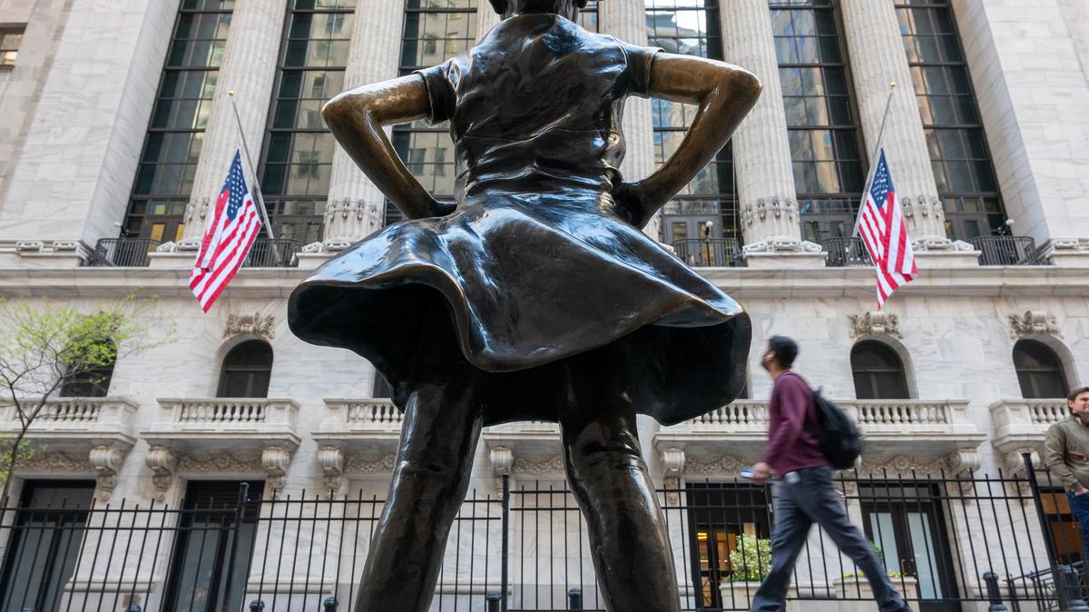 People walk past the Fearless Girl statue outside of the New York Stock Exchange (NYSE) on April 28, 2025, in New York City.