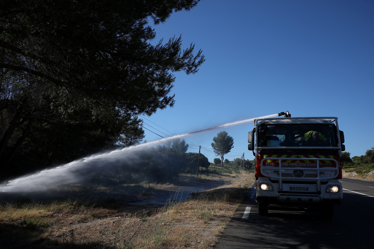 A fire truck sprays water to contain a wildfire in Lancon-Provence near Marseille, France, July 2, 2026. REUTERS/Manon Cruz