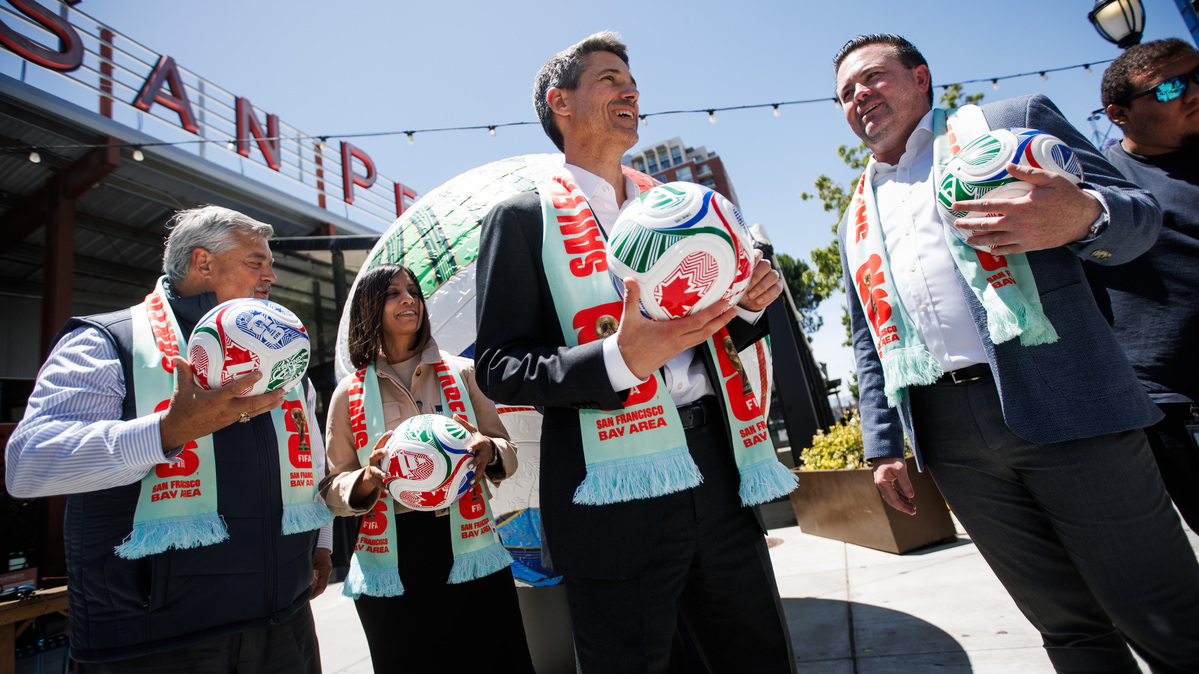 San Jose Mayor Matt Mahan, center, San Jose Earthquakes President Jared Shawlee, right, San Jose Sports Authority Executive Director John Poch, far left, and Bay Area Host Committee CEO and President Zaileen Janmohamed, second from left, stand in front of a large Trionda World Cup soccer ball installation after a group photo outside San Pedro Square Market during a news conference on Monday, June 8, 2026, in San Jose, Calif. (Dai Sugano/Bay Area News Group)