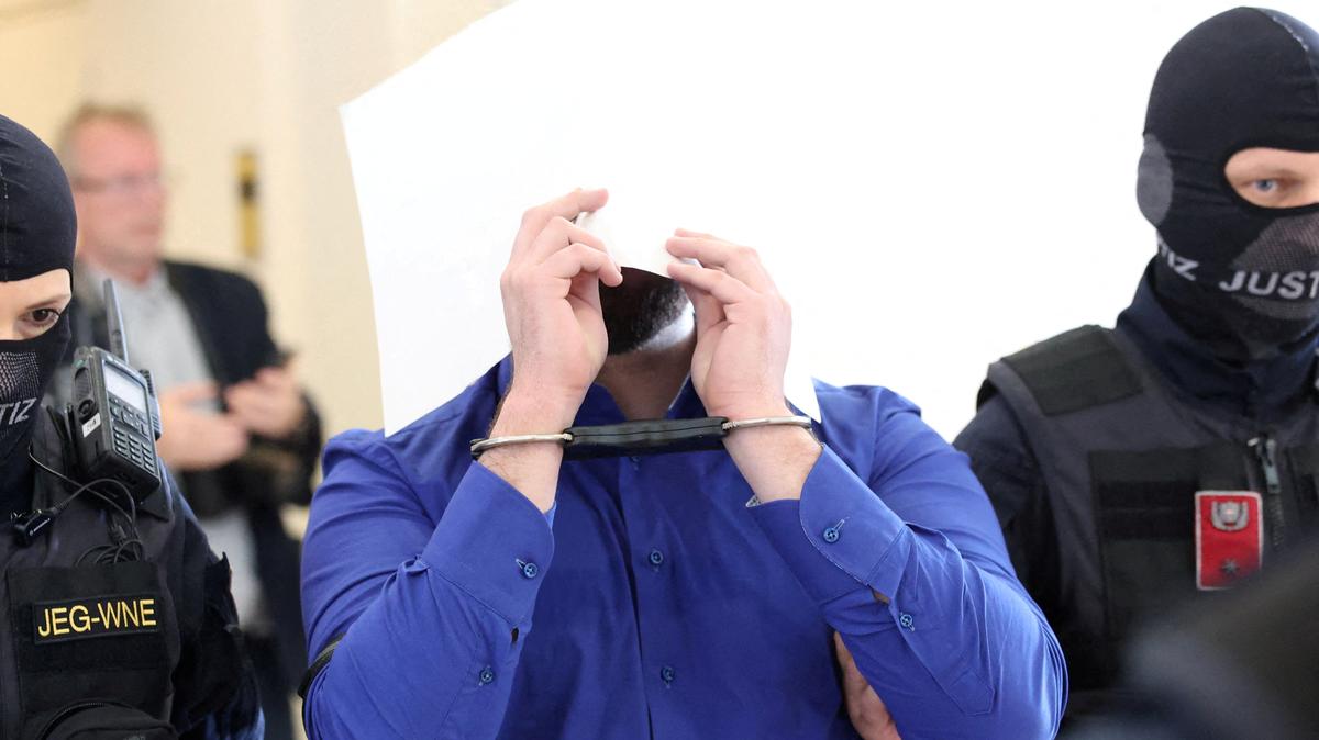 FILE PHOTO: The defendant, an Austrian identified as Beran A, one of the men suspected of planning an attack on Taylor Swift's Vienna concert in 2024, is escorted by security personnel during a break in a courtroom for his trial in Wiener Neustadt, Austria, April 28, 2026.REUTERS/Leonhard Foeger/File Photo