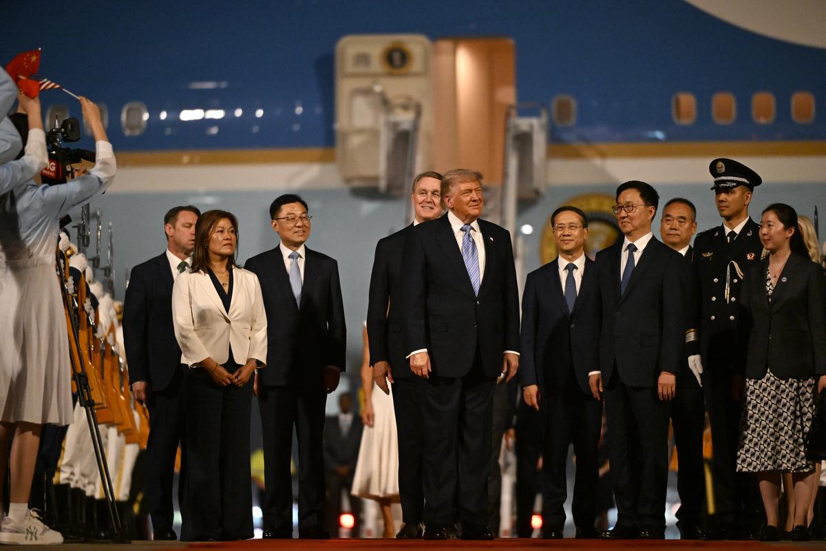 A smiling President Donald Trump, center, is welcomed to Beijing Capital International Airport in Beijing, China, on Wednesday, May 13, 2026. Trump is in China for a two-day summit with China's leader, Xi Jinping. (Kenny Holston/The New York Times)