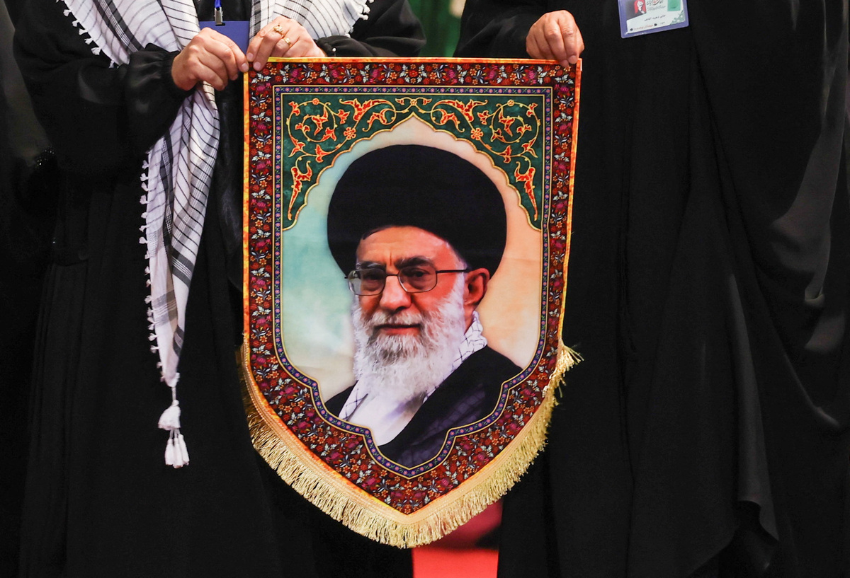 Women hold an image of Iran's late Supreme Leader Ayatollah Ali Khamenei as they walk to pay their respects near the coffins of Khamenei and his family members, on the day international delegates participate in a farewell ceremony for Khamenei, who was killed on February 28 during Israeli and U.S. airstrikes on Iran, at the Imam Khomeini Grand Mosalla in Tehran, Iran July 3, 2026. REUTERS/Mohammed Salem
