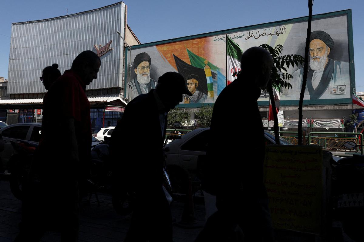 People walk past a mural depicting the late leader of the Islamic Revolution, Ayatollah Ruhollah Khomeini, and Iran's late Supreme Leader Ayatollah Ali Khamenei, in Tehran, Iran, May 25, 2026. Majid Asgaripour/WANA (West Asia News Agency) via REUTERS