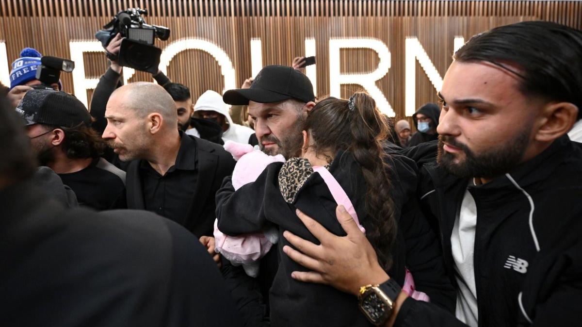 A group of supporters surround an ISIS-linked family as they arrive at Melbourne International Airport in Melbourne, Australia, Thursday. The group of 13 women and children came home to Australia after years spent in a Syrian refugee camp following the fall of the Islamic State. Three of the women have been charged with crimes. Photo by Joel Carrett/EPA
