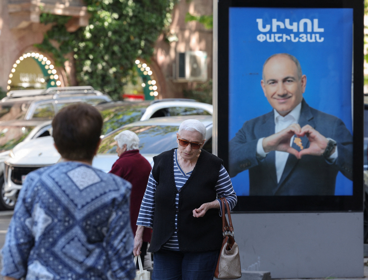 People walk past campaign banners with portraits of Prime Minister Nikol Pashinyan of the Civil Contract party, ahead of the June 7 parliamentary election, in Yerevan, Armenia June 3, 2026. Hayk Baghdasaryan/Photolure via REUTERS