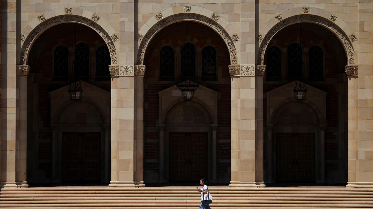 A woman walks by Royce Hall at the University of California Los Angeles (UCLA) in Los Angeles, California, U.S., August 11, 2025. REUTERS/Daniel Cole